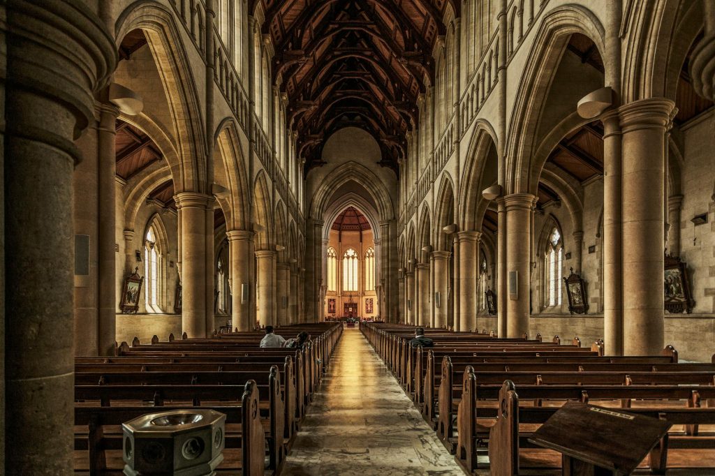 A beautifully detailed interior of a gothic-style historic cathedral with arches and pews.